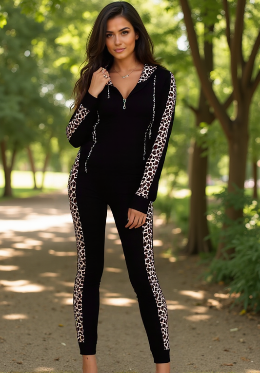 Woman wearing a black outfit with leopard print sleeves and pants in a park setting